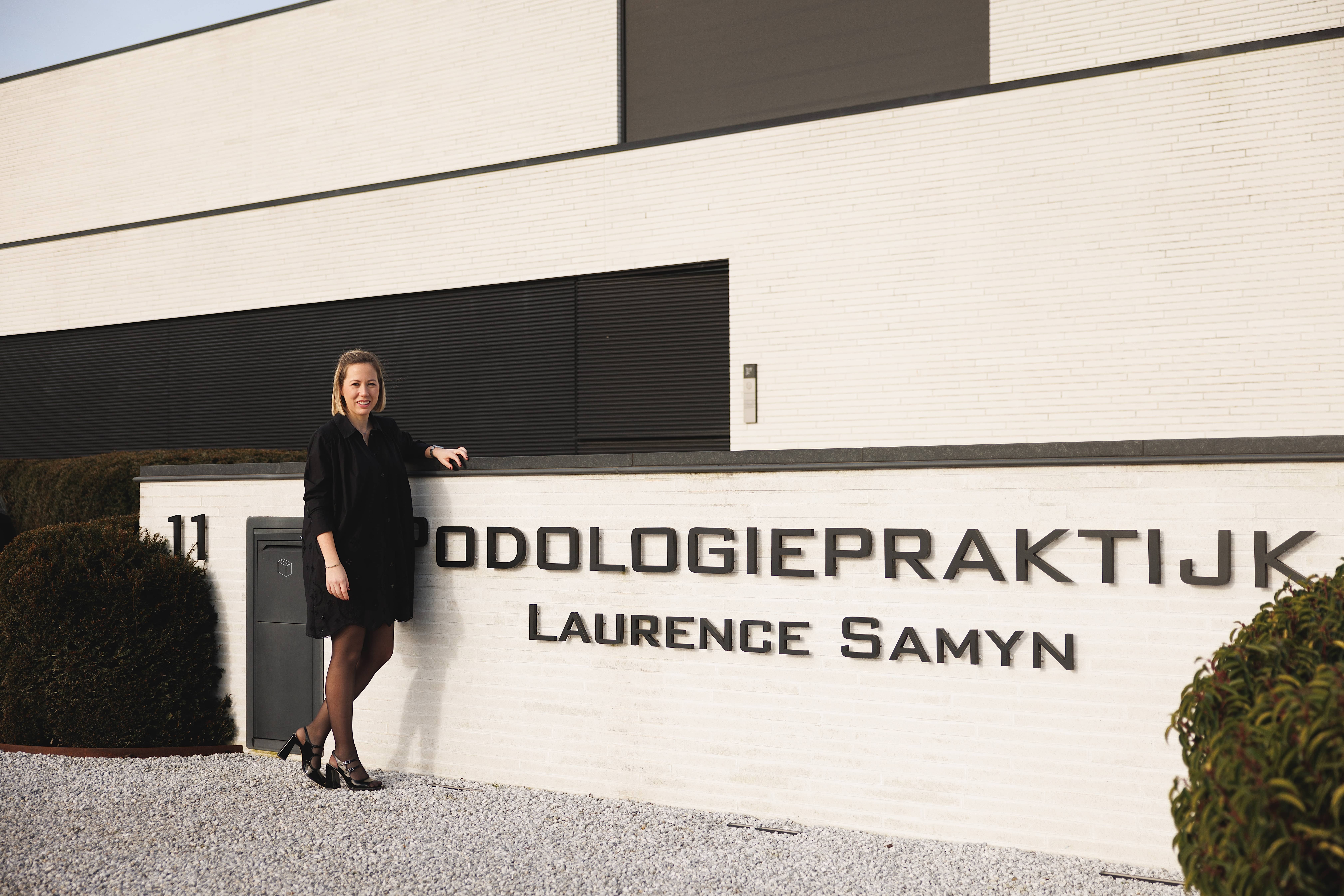 Foto Laurence Samyn bij ingang podologiepraktijk